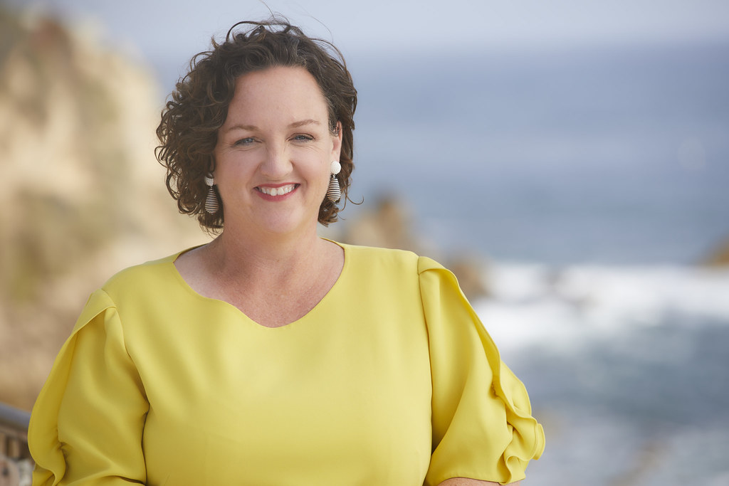 Katie Porter, smiling, with the California coast behind her